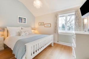 a bedroom with a white bed and a window at Sundial Lodge in Wilby