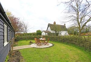a patio with a table and chairs in front of a house at Sundial Lodge in Wilby
