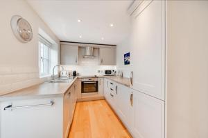a kitchen with white cabinets and a clock on the wall at Sundial Lodge in Wilby +7 photos