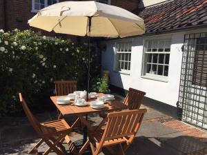 een houten tafel en stoelen onder een paraplu bij 2 Bed in Eye oc-4lamb in Eye