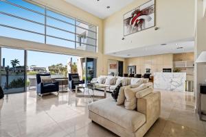 Una gran sala de estar con un sofá y sillas. en 3BR Riverfront Retreat with Office, Pool & Pontoon, en Gold Coast