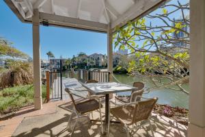 Una mesa y sillas en un patio con vista al agua. en Stylish Studio Escape in the Heart of the GC, en Gold Coast