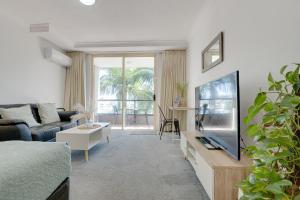 Una sala de estar con un sofá y un televisor de pantalla plana. en Stylish Studio Escape in the Heart of the GC, en Gold Coast