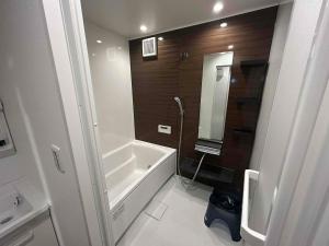 a bathroom with a bath tub and a sink at いすみスローライフ in Chōjamachi