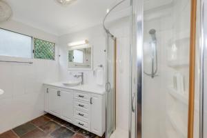 Un baño blanco con lavabo y ducha. en 55 See Street Bargara, en Bargara 37 fotos más