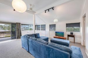 Una sala de estar con un sofá azul y una mesa. en 55 See Street Bargara, en Bargara