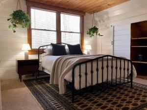 a bedroom with a bed with blue pillows on it at Modern Mountaintop Cabin with a gorgeous view in Great Cacapon