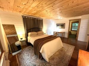 a bedroom with a bed and a wooden ceiling at Modern Mountaintop Cabin with a gorgeous view in Great Cacapon