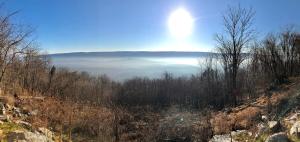 a view of a foggy valley with the sun in the sky at Modern Mountaintop Cabin with a gorgeous view in Great Cacapon +28 photos