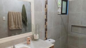 ein Badezimmer mit Waschbecken, Toilette und Spiegel in der Unterkunft Bosque de Ángeles in Buena Vista + 39 Fotos