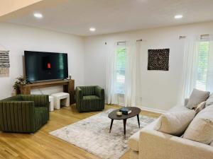 a living room with a couch and two chairs and a tv at The Marietta Haus in Marietta