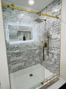 a bathroom with a shower with a stone wall at The Marietta Haus in Marietta