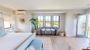 a bedroom with a bed and a table with stools at HOKU LANI HOUSE Heated Private Pool Spa Intro Pricing 25% off in Waimea +89 photos