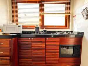 a kitchen with wooden cabinets and a microwave at Casa Vista Verde in Paraty +33 photos