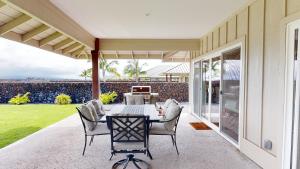 a dining room with a table and chairs on a patio at ADVENTURE AWAITS Fun 4BR Ainamalu Home with Private Pool in Waikoloa