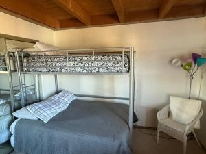 a bedroom with a bunk bed and a chair at Summit County Wildernest Condo in Silverthorne +18 photos