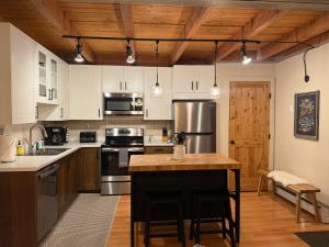 a kitchen with white cabinets and a wooden ceiling at Summit County Wildernest Condo in Silverthorne