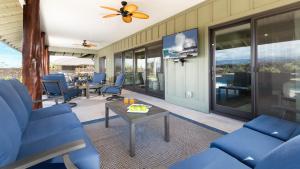Una sala de estar con sillas azules y una mesa. en ❤PiH❤Aloha Paradise Large Private Pool Waterfall Spa PLUS 2024 Resort Pool Passes, en Waikoloa