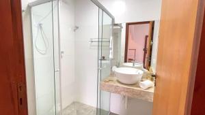 a bathroom with a glass shower and a sink at Casa Vista Verde in Paraty