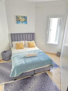 une chambre avec un lit avec une couverture bleue dans l'établissement Appartement freedom, à Agadir