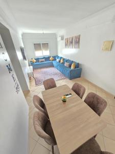 un salon avec une table et un canapé bleu dans l'établissement Appartement freedom, à Agadir