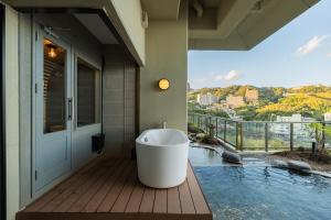 a bathroom with a tub on a deck with a view at IZU RETREAT by Onko Chishin in Higashiizu