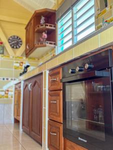 a kitchen with a black oven and wooden cabinets at Gîte Soleil Canne in Capesterre-de-Marie-Galante