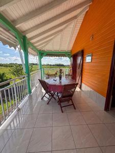 a patio with a table and chairs on a balcony at Gîte Soleil Canne in Capesterre-de-Marie-Galante