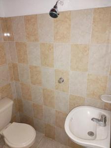 a bathroom with a toilet and a sink at Casa Zona Rosa in La Dorada