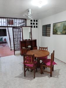 a dining room with a table and chairs and a mirror at Casa Zona Rosa in La Dorada