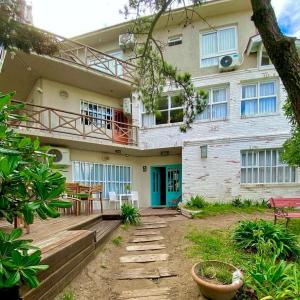 a house with a blue door and a patio at Romina Art Hotel in Villa Gesell