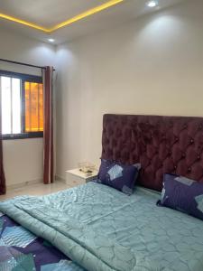 Un dormitorio con una cama grande con un cabecero grande. en Un luxe à Ngor, en Dakar