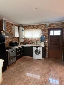 a kitchen with a dishwasher and a washer in it at Trainer Center House in Tres Arroyos