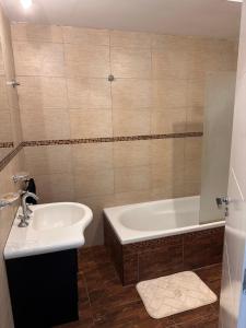 a bathroom with a sink and a bath tub at Trainer Center House in Tres Arroyos +13 photos