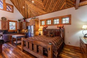 a bedroom with a large bed and a kitchen at River Sound Cabin at Eagles Nest in Banner Elk +39 photos