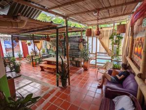 a woman sitting on a couch in a living room at Hostal Rolled in Villavieja