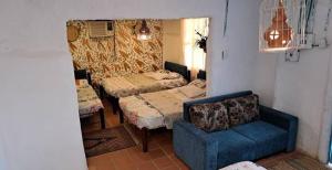 a living room with two beds and a blue chair at Hostal Rolled in Villavieja