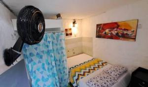 a small room with a bed and a fan at Hostal Rolled in Villavieja