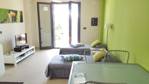 Appartamento Verde Taormina في تاورمينا: غرفة معيشة مع أريكة وتلفزيون