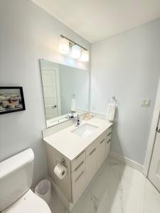a white bathroom with a sink and a mirror at Charming Stay in London in London