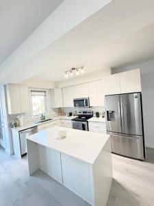 a large kitchen with a refrigerator and a table at Charming Stay in London in London