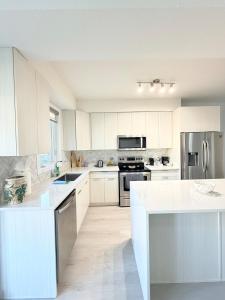 a kitchen with white cabinets and a white counter top at Charming Stay in London in London +20 photos