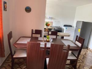 a dining room with a table and chairs and a kitchen at Departamento en Loja in Loja
