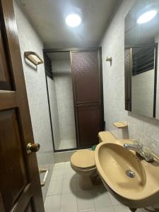 a bathroom with a sink and a toilet and a mirror at Apartaestudio loft frente al parque Santander in Moniquirá