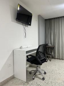 a desk with a chair and a monitor on a wall at Apartaestudio loft frente al parque Santander in Moniquirá