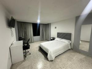 a bedroom with a bed and a desk and a television at Apartaestudio loft frente al parque Santander in Moniquirá