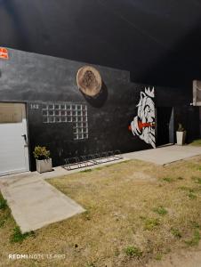 a building with a painting on the side of it at Trainer Center House in Tres Arroyos