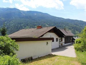 uma casa com um telhado com montanhas ao fundo em Yannsa em Untertweng