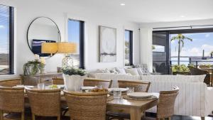 a living room with a table and chairs at Echoes - Luxury Home Beach Views Walk to Cafes in Woolgoolga