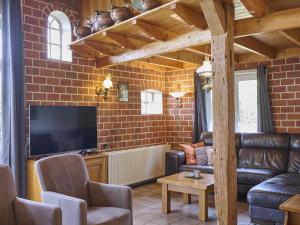 a living room with a couch and a tv at Erve Koeleman in Neede